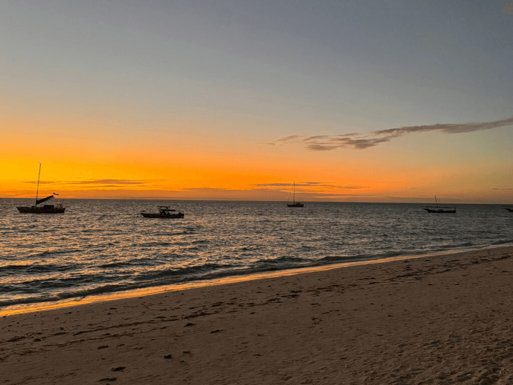 Traditional dhow boat sailing at sunset off Zanzibar coast