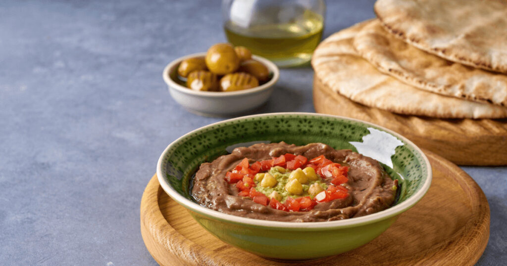Traditional Egyptian breakfast ful medames served with olive oil and herbs | Egypt vacation tips