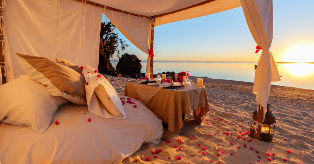 Luxury beach resorts Egypt – candlelit dinner setup on the Red Sea shore for honeymooners.